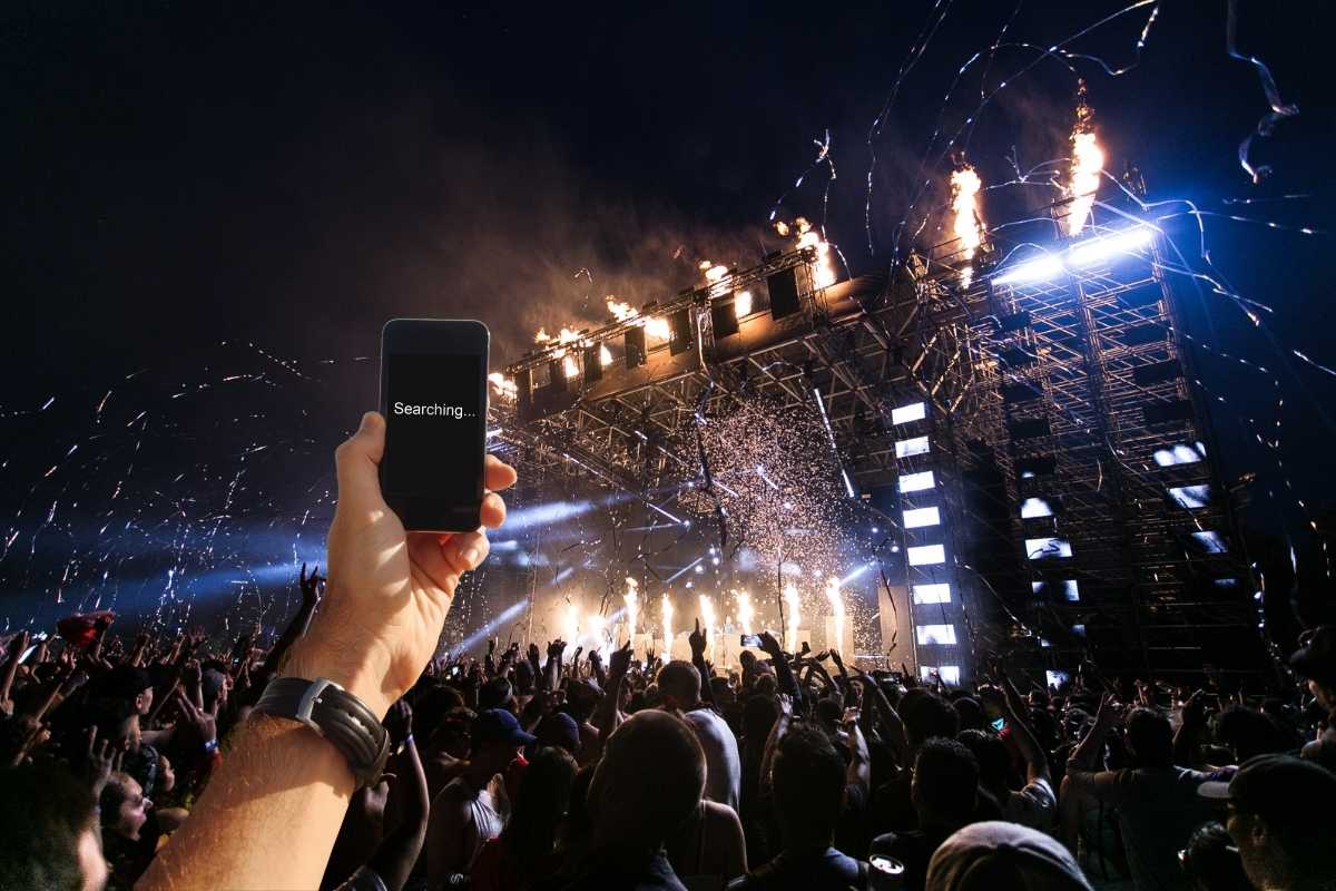 Una mano con cellulare che non riceve ad un concerto